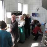 Arbeitsaufteilung in der Küche, fröhliches Grinsen bei allen Beteiligten